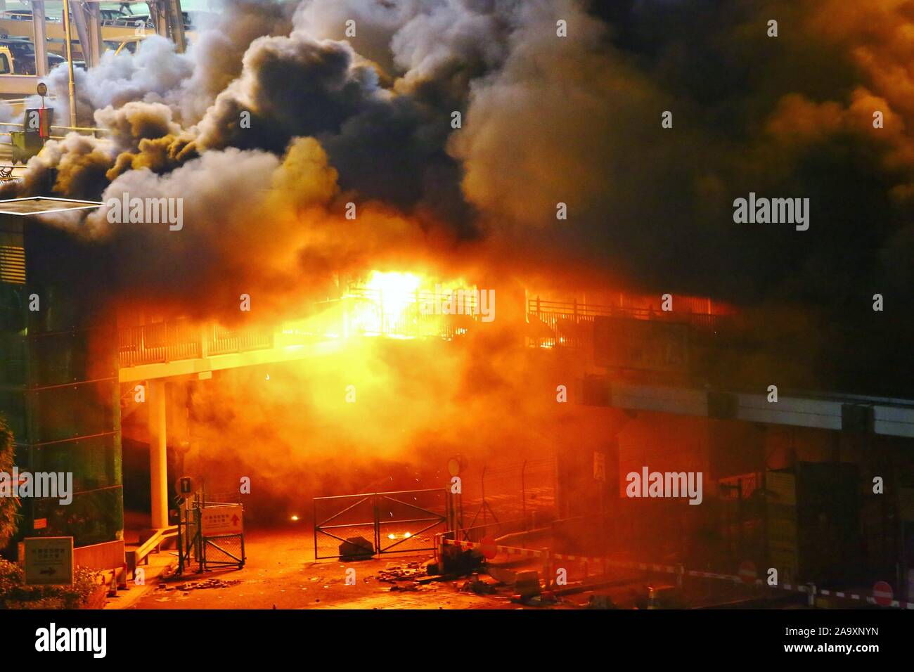 Hong Kong, China. 17th Nov, 2019. Protesters set fire to the entrance of Hong Kong's Polytechnic University to stop riot police from entering. Here protesters and police clash on a bridge connecting the campuses at the Hong Kong Polytechnic University on Sunday night. Credit: Gonzales Photo/Alamy Live News Stock Photo