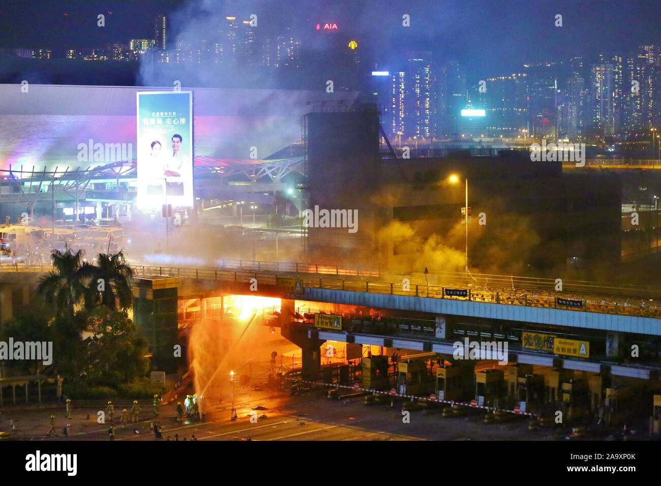 Hong Kong, China. 17th Nov, 2019. Protesters set fire to the entrance of Hong Kong's Polytechnic University to stop riot police from entering. Here protesters and police clash on a bridge connecting the campuses at the Hong Kong Polytechnic University on Sunday night. Credit: Gonzales Photo/Alamy Live News Stock Photo