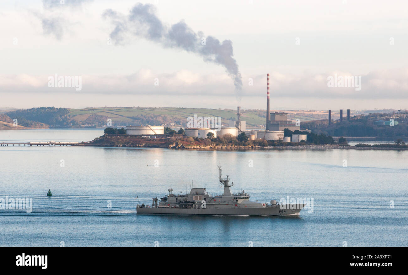 Crosshaven, Cork, Ireland. 18th November, 2019. Irish Naval Ship LÉ George Bernard Shaw passing the ESB generating Station and oil storage tanks  in Aghada as she heads out of the harbour on patrol in Co. Cork, Ireland. Credit; David Creedon / Alamy Live News Stock Photo