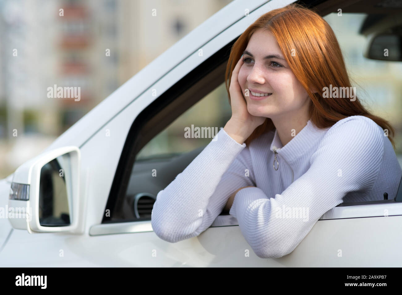 Young woman with red hair driving a car Stock Photo - Alamy