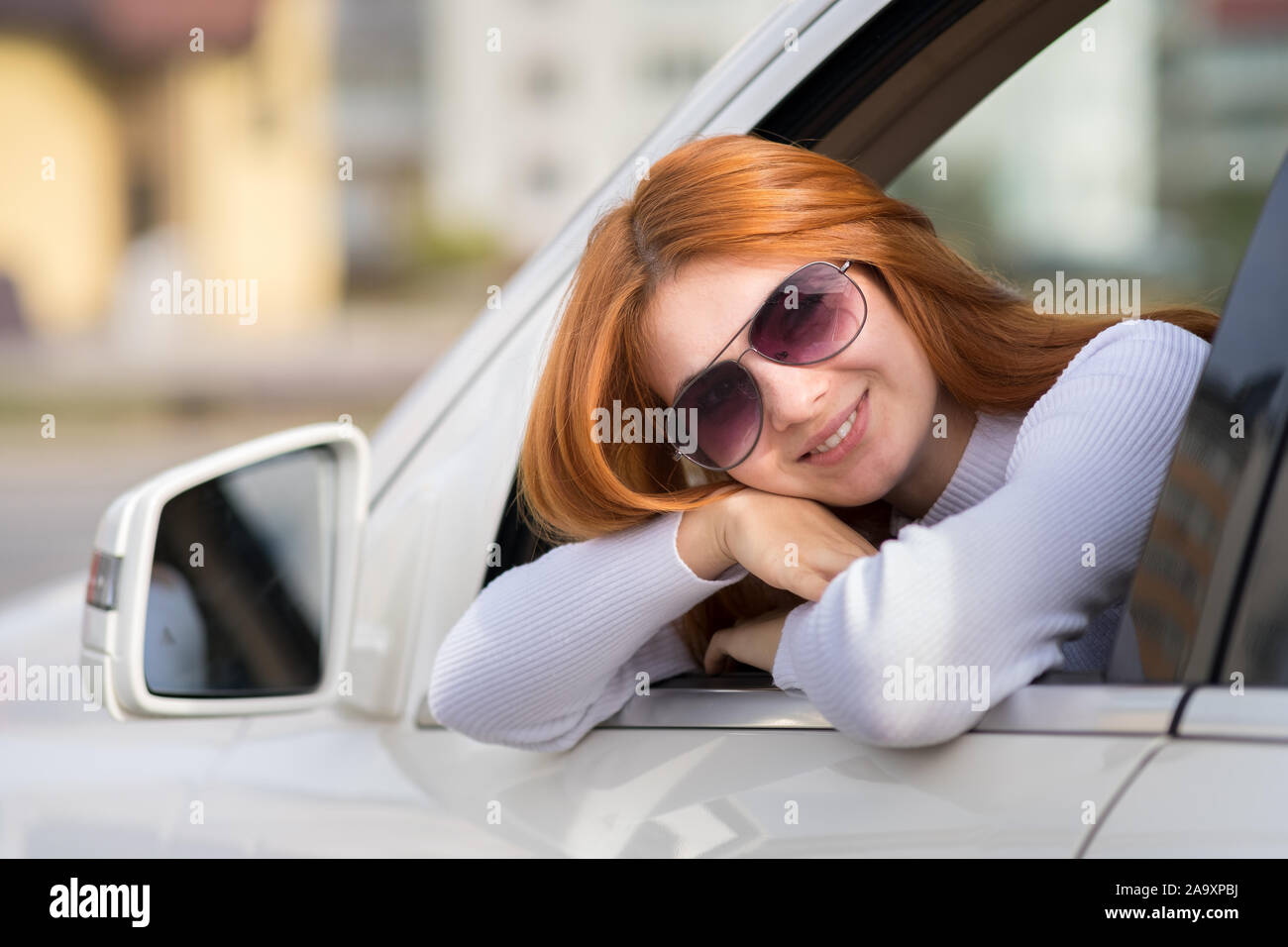 Young woman with red hair driving a car Stock Photo - Alamy