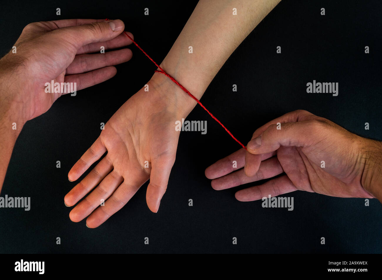 Red thread on a black background in the cart Stock Photo - Alamy