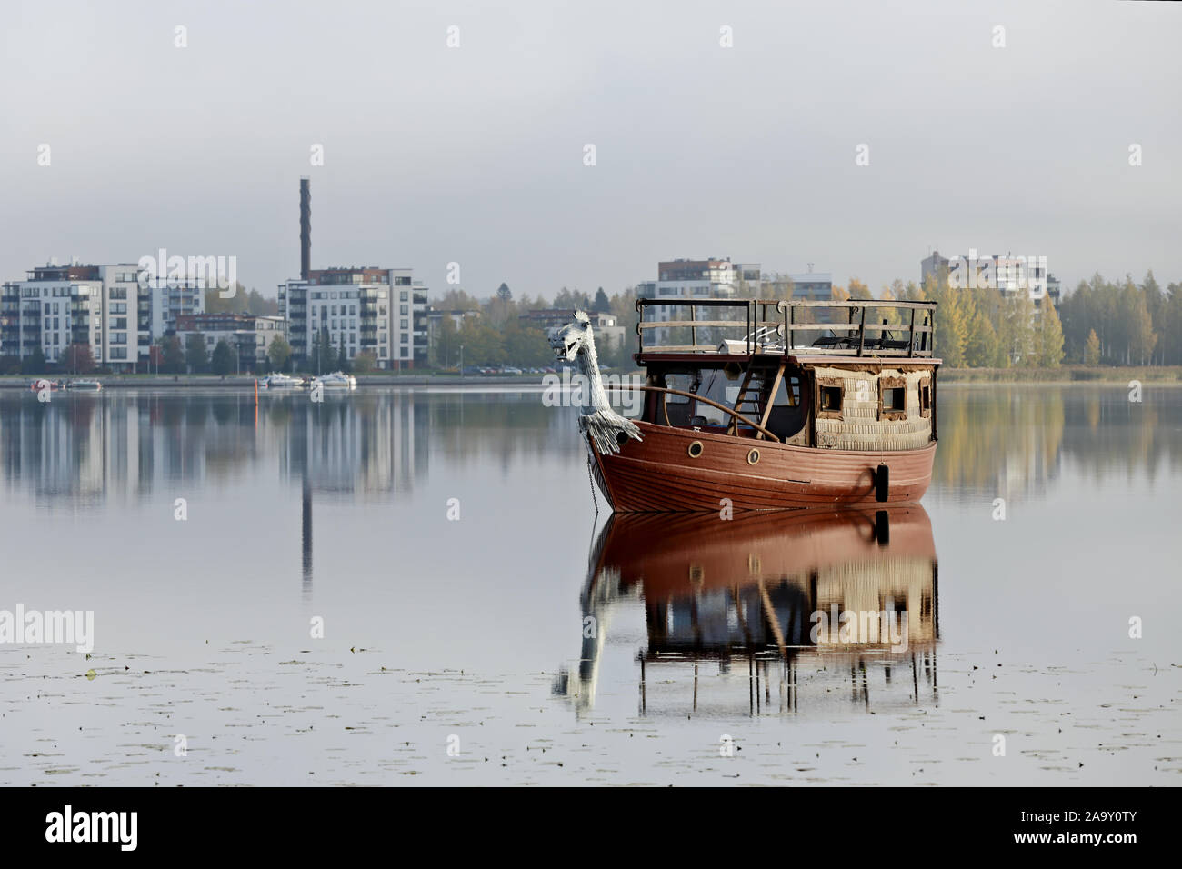 Hameenlinna, Finland 10/02/2018A boat with steely dragon head on a calm lake in autumn day Stock Photo