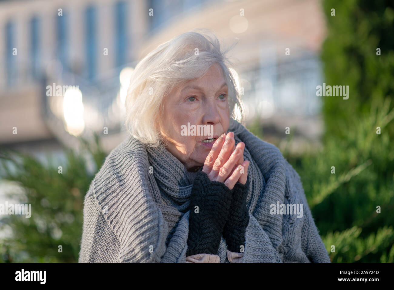 Blue-eyed homeless pensioner feeling miserable and hungry Stock Photo
