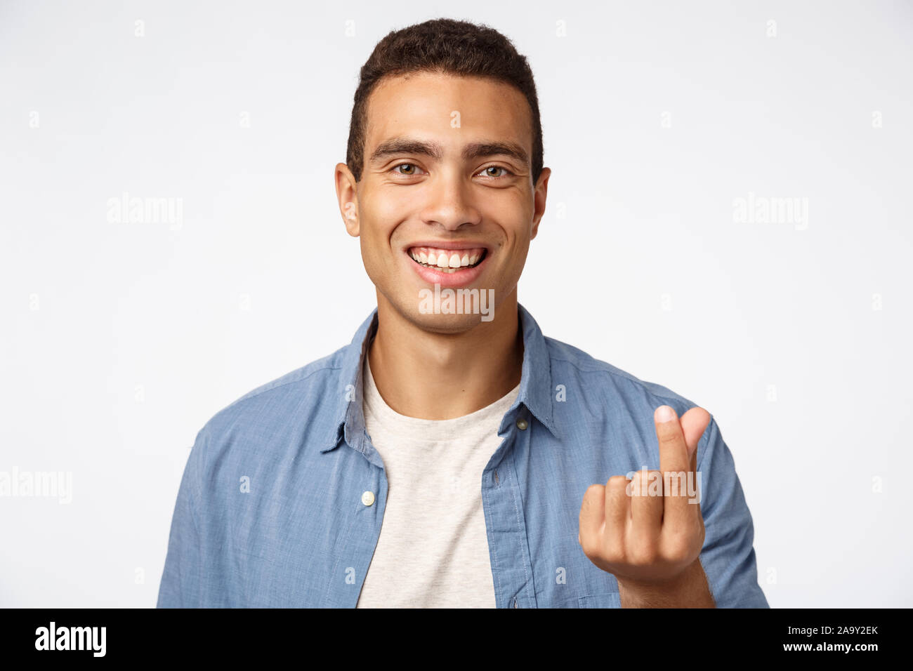 Handsome cheerful young caucasian man in blue shirt over tshirt