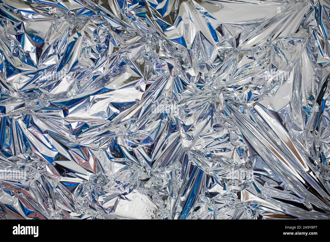Decoration background of metal crumpled foil, shiny silver surface Stock Photo