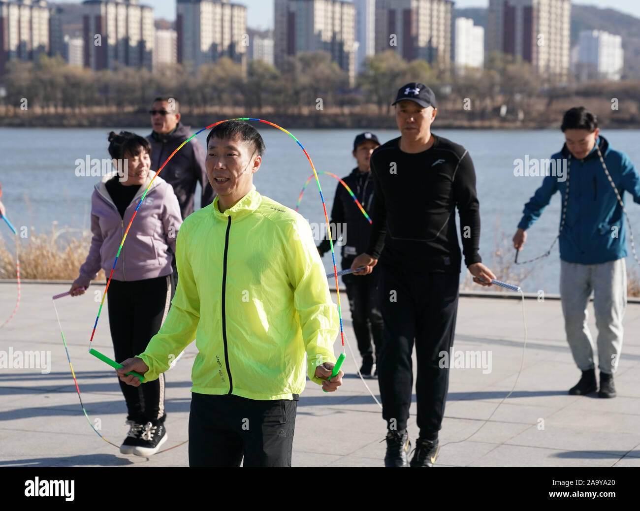 (191118) -- BEIJING, Nov. 18, 2019 (Xinhua) -- Hou Weidong (front) practises with his students at a square in Jilin City, northeast China's Jilin Province, Nov. 5, 2019. Hou Weidong, 41 years old, is a national coach who specializes in rope jumping skills. Meanwhile, he also is a professional athlete of rope jumping. In the beginning, rope jumping was just his daily fitness routine in the park. Gradually, his astonishing performance attracted lots of people to learn from him, so he embarked on a coaching road. In 2014, he and his students began to attend national rope jumping competitions and Stock Photo