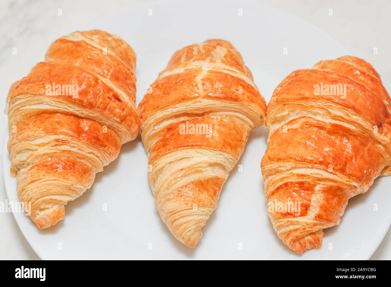 Plain croissant on white background - Image Stock Photo