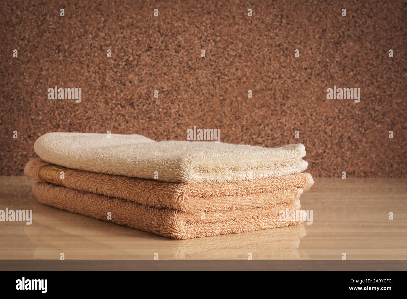 A Stack Of Beige Terry Towels On A Chest Of Drawers Selective