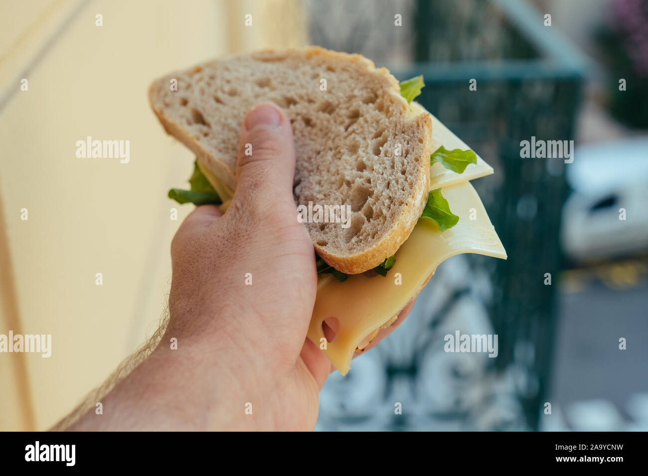 Tasty Sandwich with ham and salad in the hand Stock Photo