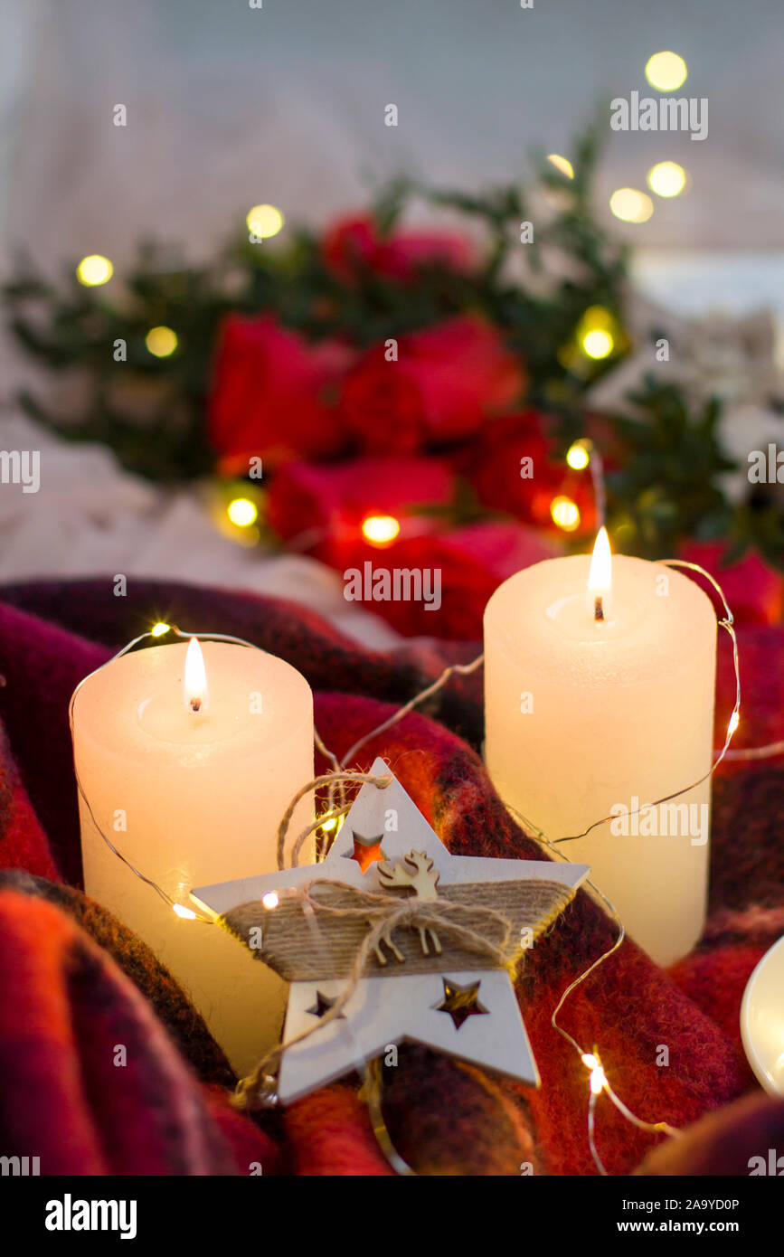 Composition: red roses with boxwood, candles, a garlands , red blanket and star. Stock Photo