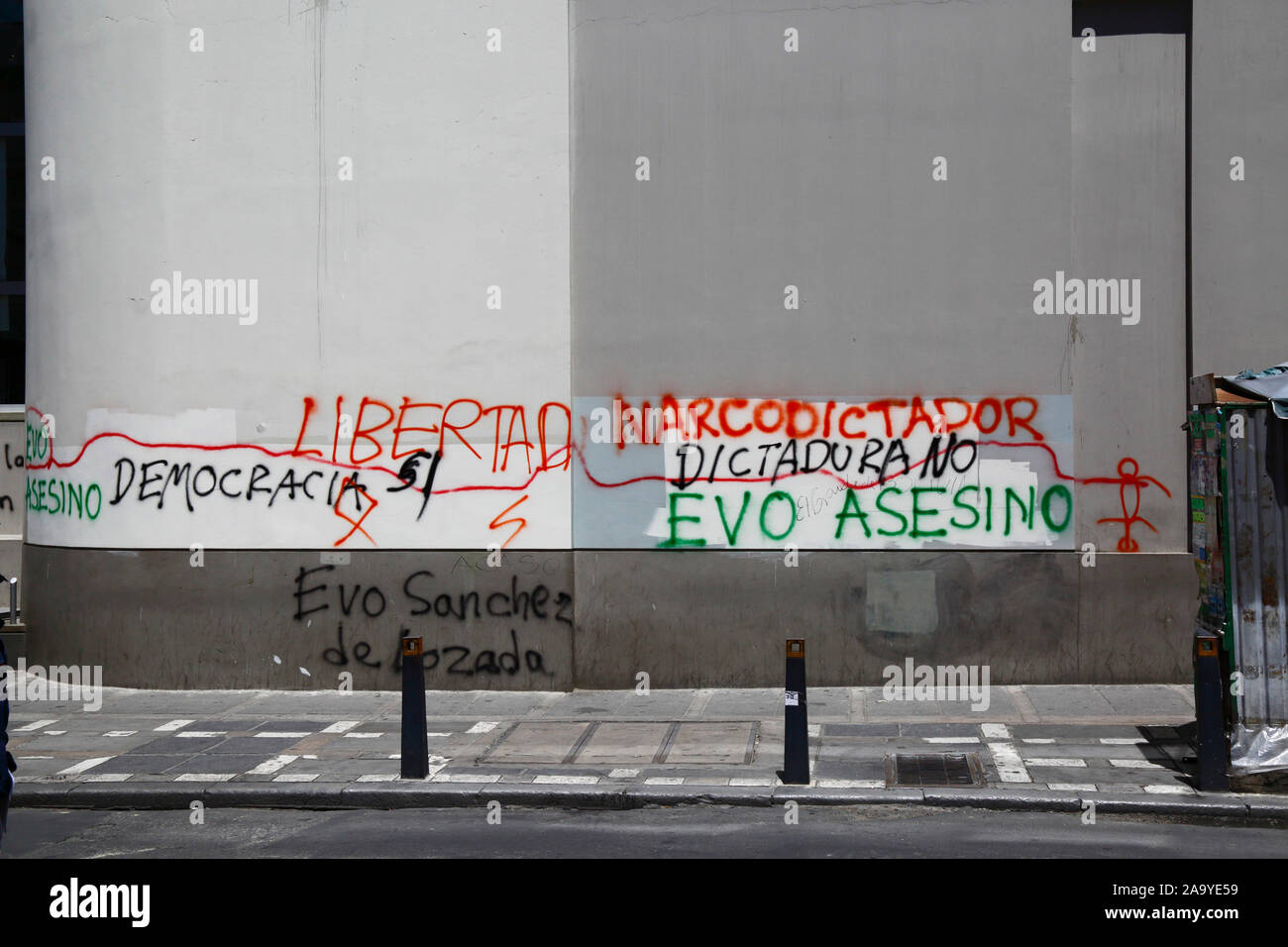La Paz, Bolivia, 18th October 2019. 'Democracy. Liberty. Narco dictator, No dictatorship, Evo killer, Evo Sanchez de Lozada' graffiti on wall of building in central La Paz. Bolivia held presidential elections on 20th October, a subsequent investigation by the OAS confirmed a large number of irregularities and president Evo Morales resigned on 10th November. Stock Photo
