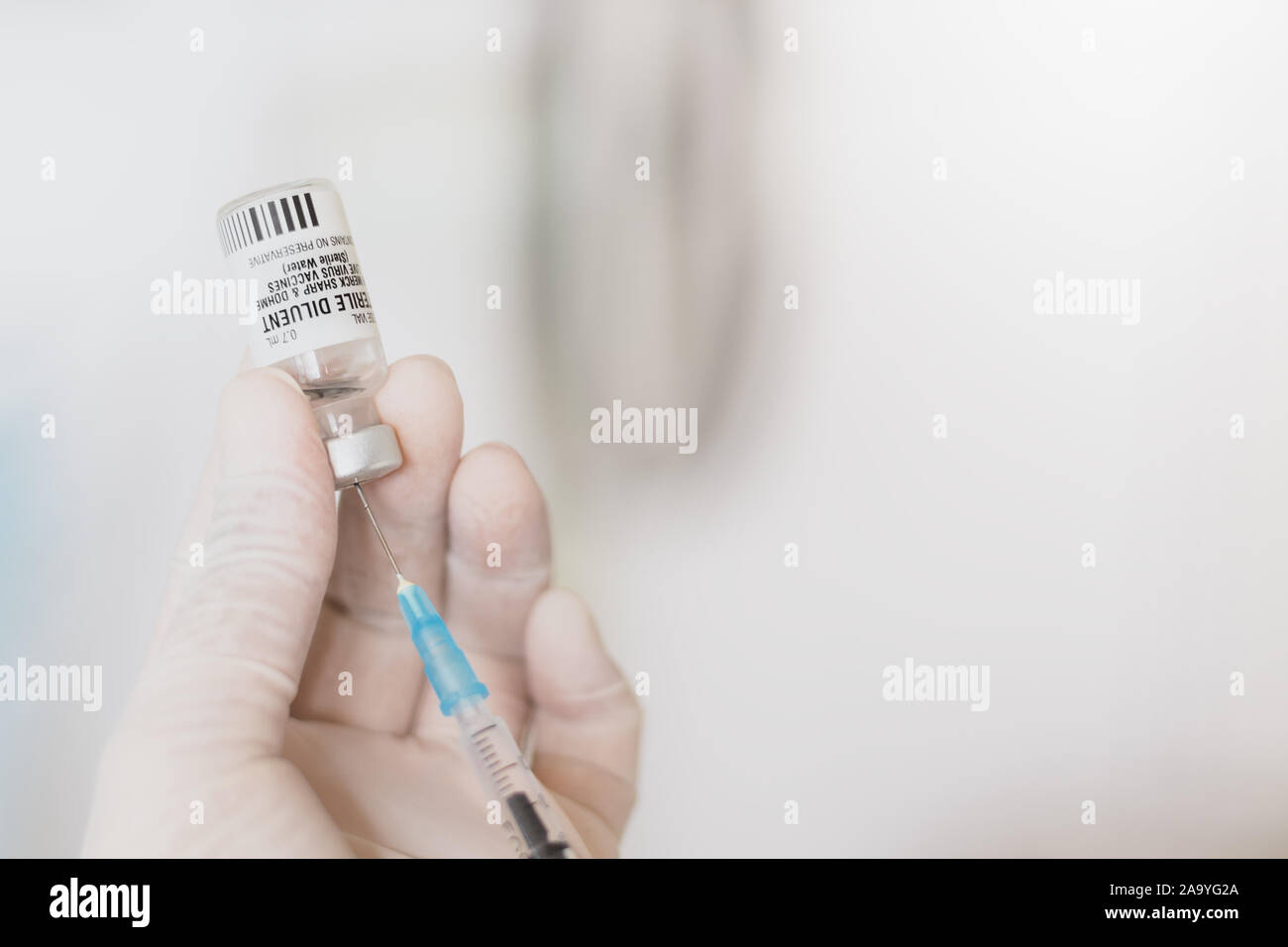 Doctor hand dilute sterile water medical syringe from vial in hand mix