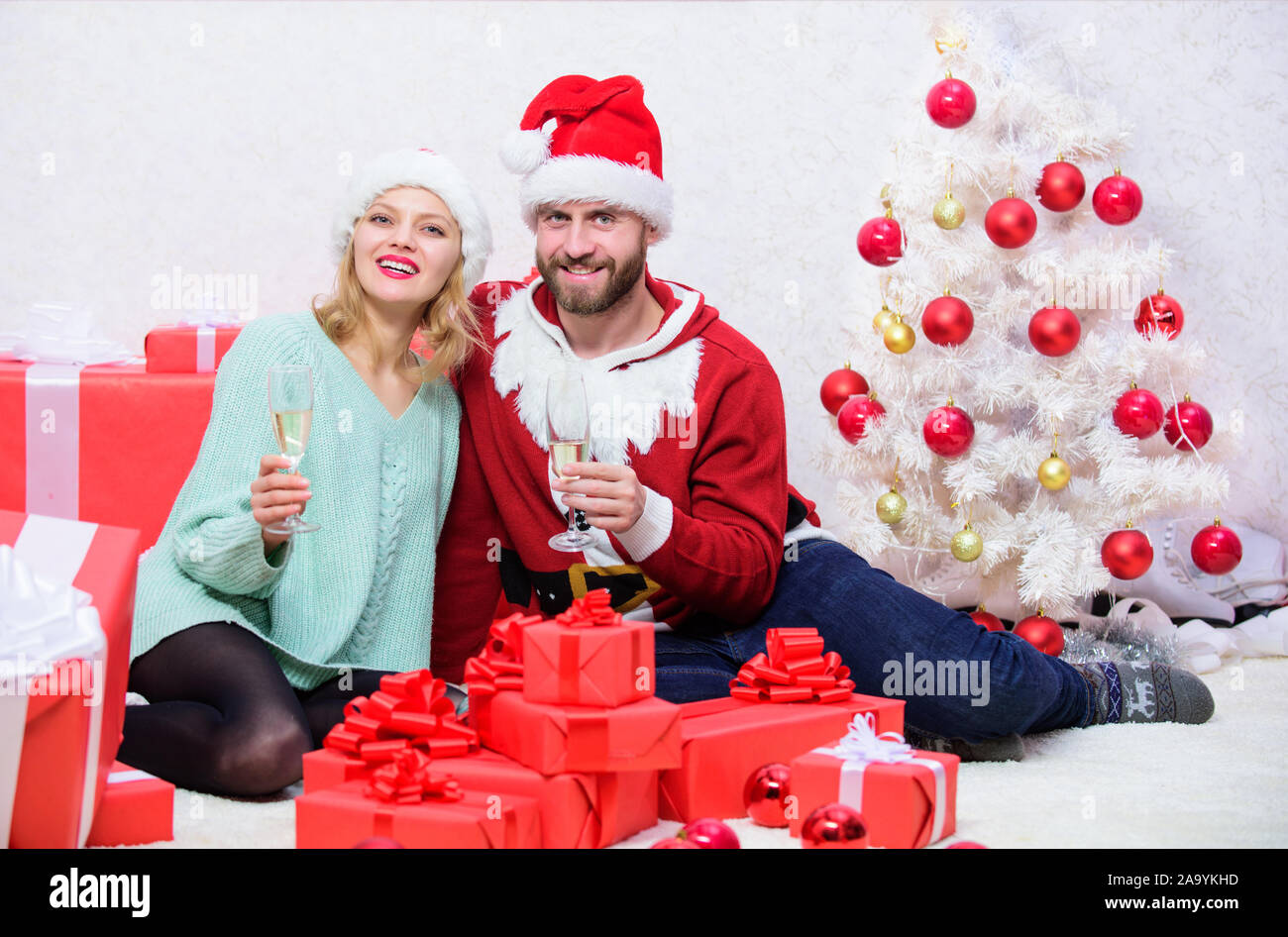 Couple wear hats as santa claus christmas tree background. Couple in love enjoy christmas celebration. It is easy to spread happiness around. Happy family celebrate christmas. Christmas fun concept. Stock Photo