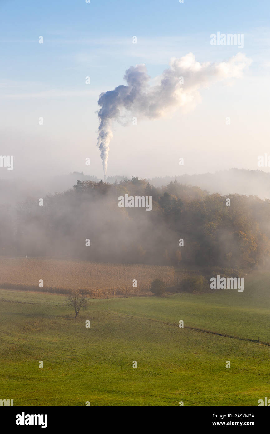 smoke of carbon dioxide (co2) from a chimney of a cement mill / factory pollutes a forest and the whole environment Stock Photo