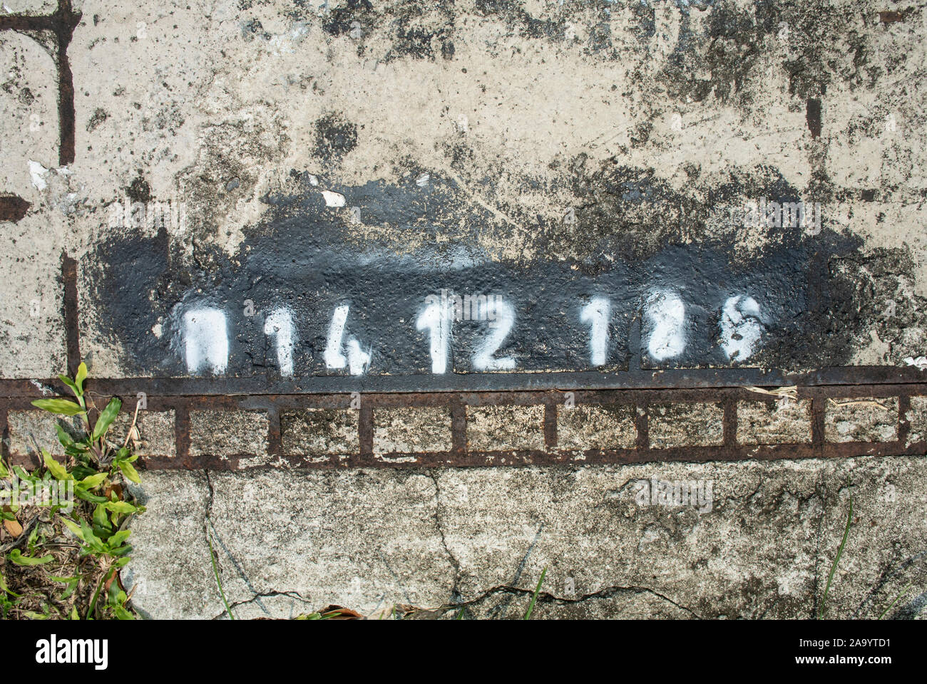Spray paint stencil fonts and numbers on the drain cover Stock Photo