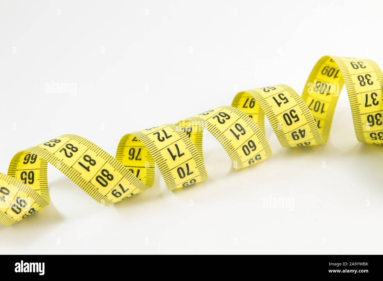 Yellow tape measure in meters and inches in a spiral Stock Photo - Alamy
