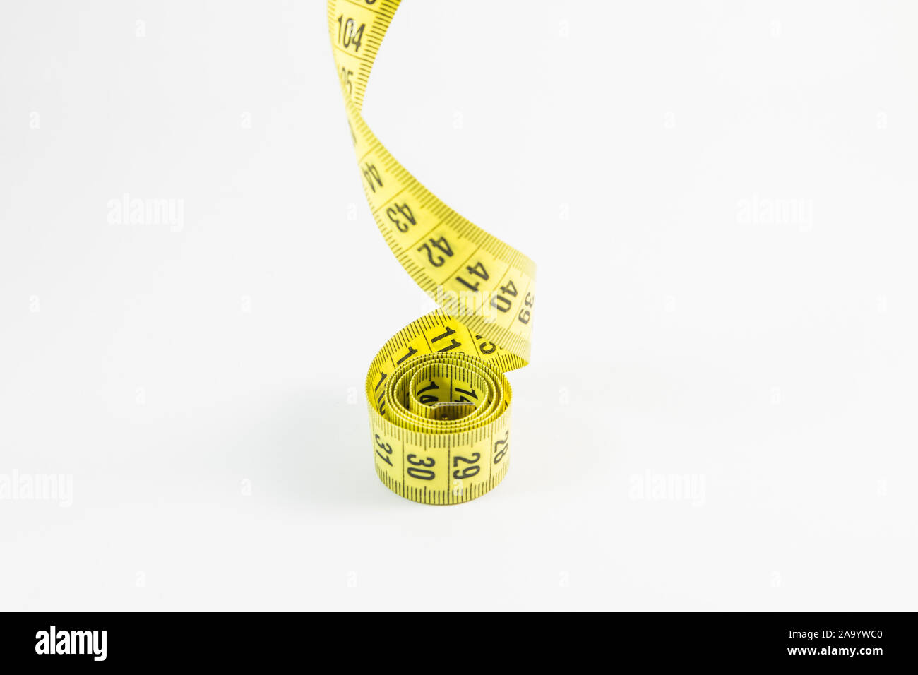 Tailors tape measure cut out against a white background. Yellow measuring  tape Stock Photo - Alamy