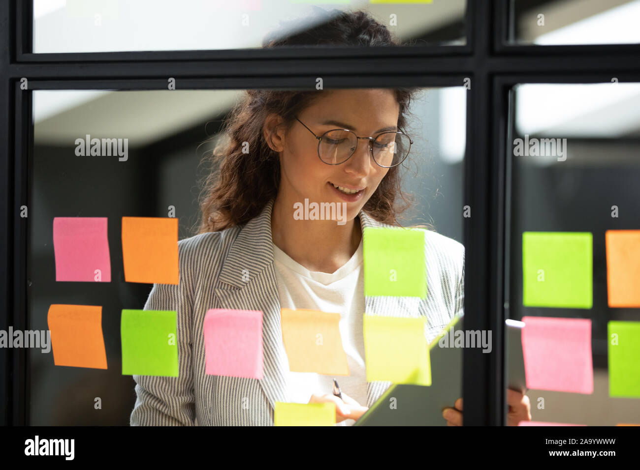 Smiling smart businesswoman using kanban agile scrum method glass board. Stock Photo