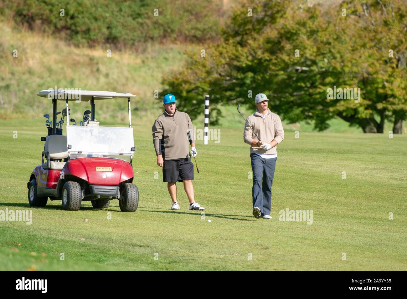 Golfers with clubs and a golf cart, outside on a sunny day, during the Johns Hopkins University annual Matt Stoffel Memorial Golf Outing, October 22, 2010. From the Homewood Photography Collection. () Stock Photo