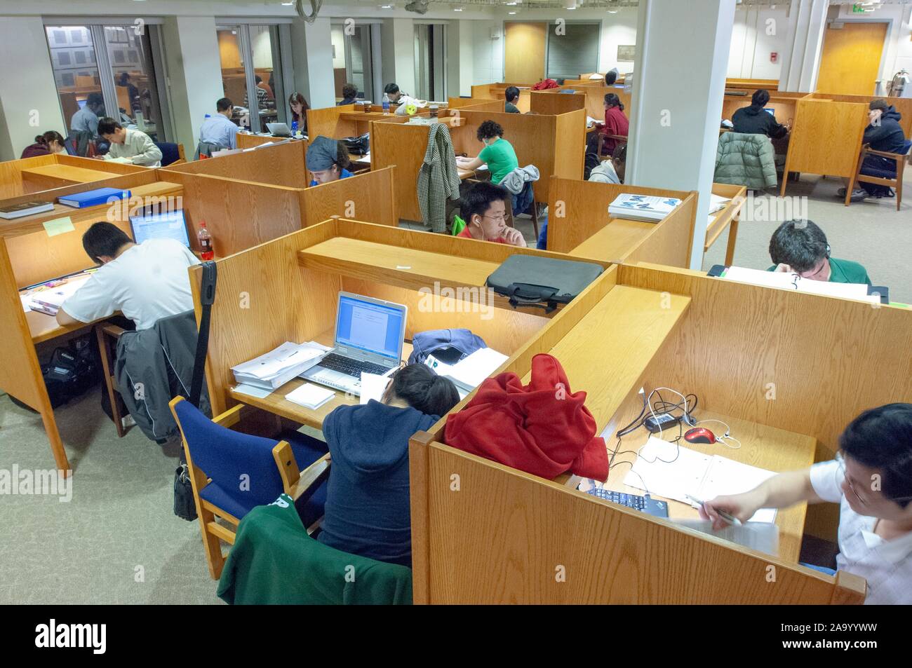 High-angle shot of students working at individual desks, in a study area in the Milton S Eisenhower Library, at the Johns Hopkins University, Baltimore, Maryland, December 12, 2007. From the Homewood Photography Collection. () Stock Photo