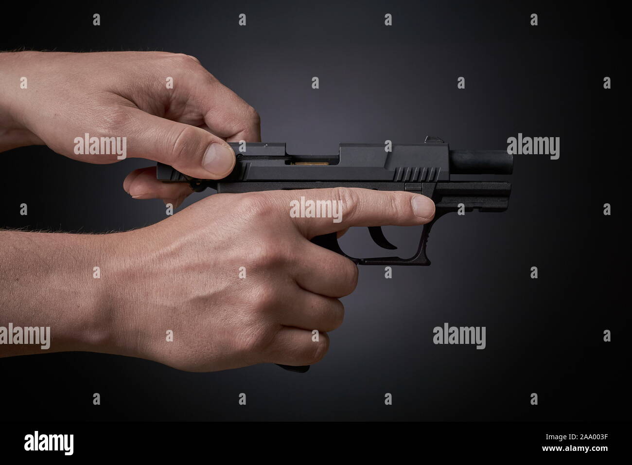 reloading a handgun, pulling back slide, side view Stock Photo