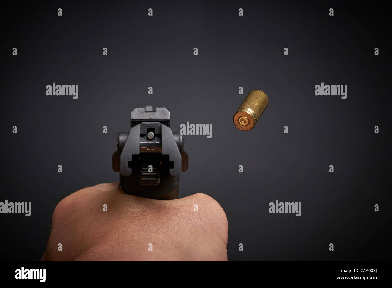 firing a handgun, lying shell, view from behind, flying empty bullet ...