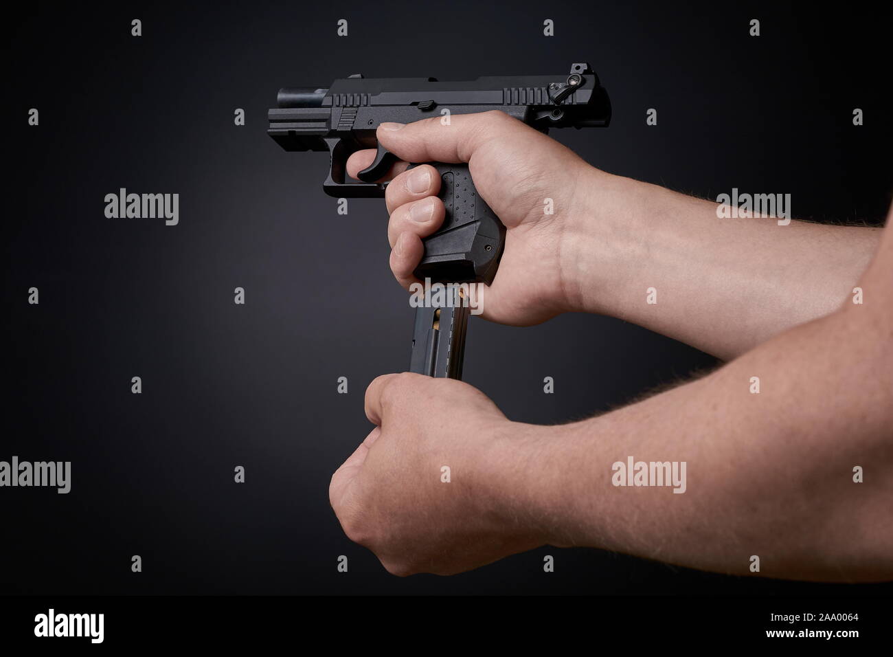reloading a handgun, inserting ammunition clip Stock Photo Alamy