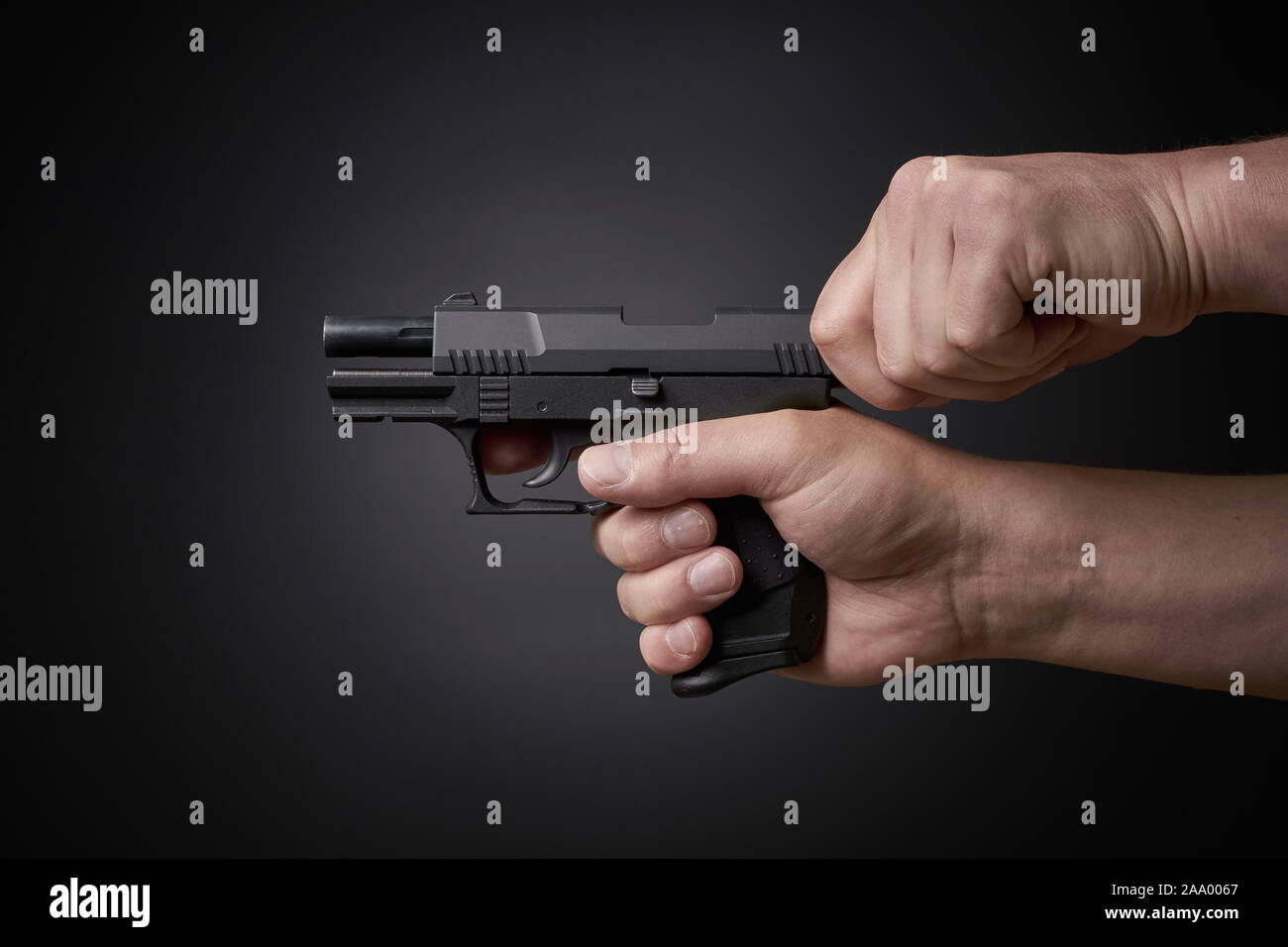 reloading a handgun, pulling back slide, side view Stock Photo