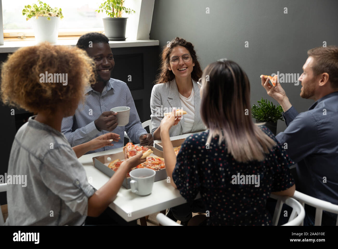 Overjoyed group of mixed race colleagues having fun on friday. Stock Photo