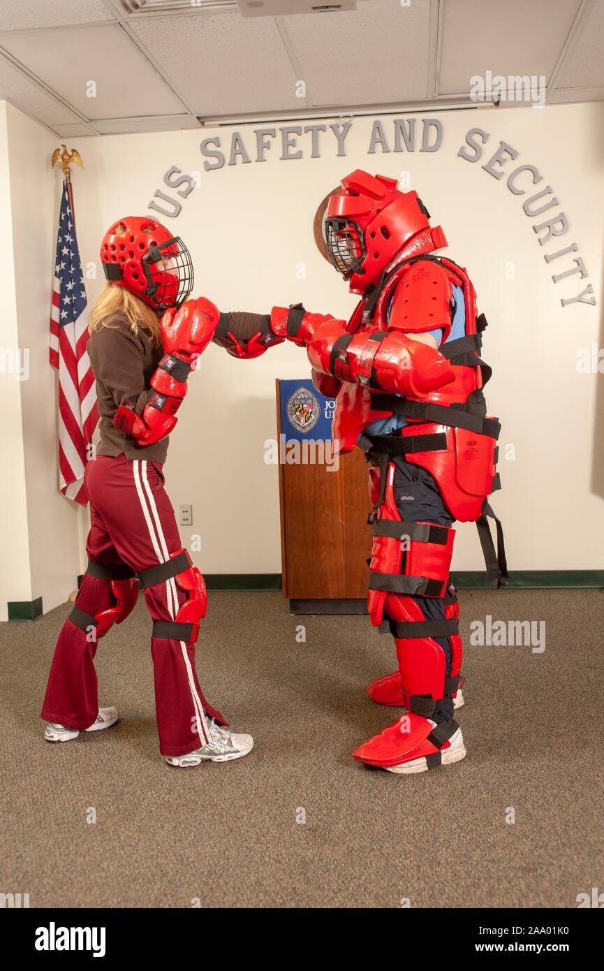 Full-length profile shot of of two people, wearing protective body gear and helmets, boxing during a campus safety and security event at the Johns Hopkins University, Baltimore, Maryland, February 19, 2009. From the Homewood Photography Collection. () Stock Photo
