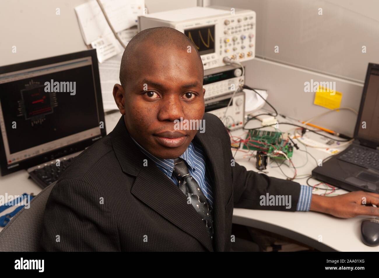 High-angle shot of engineer and inventor Ndubuisi Ekekwe, seated at a desk with computer and electronic equipment and turned to face the camera, at the Johns Hopkins University, Baltimore, Maryland, February 25, 2009. From the Homewood Photography Collection. () Stock Photo