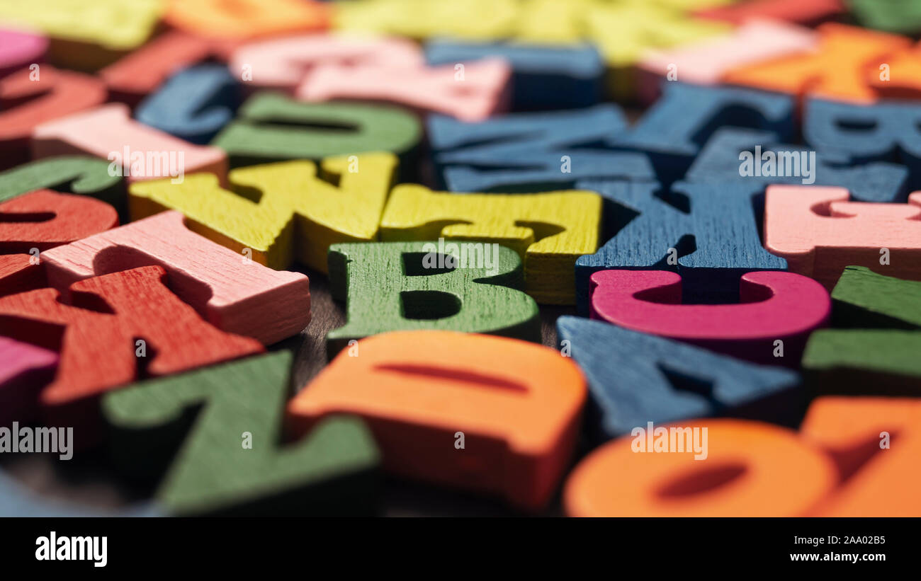 Colorful wooden letters on wooden background, shallow depth of field Stock Photo