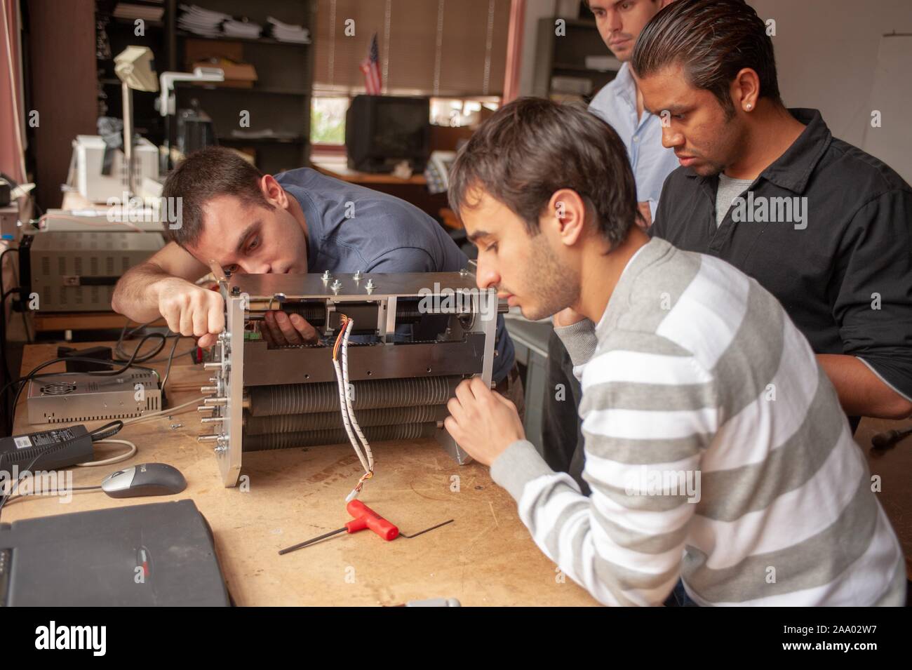 Four Whiting School of Engineering Design Team students work on a component in a machine shop at the Johns Hopkins University, Baltimore, Maryland, March 30, 2009. From the Homewood Photography Collection. () Stock Photo