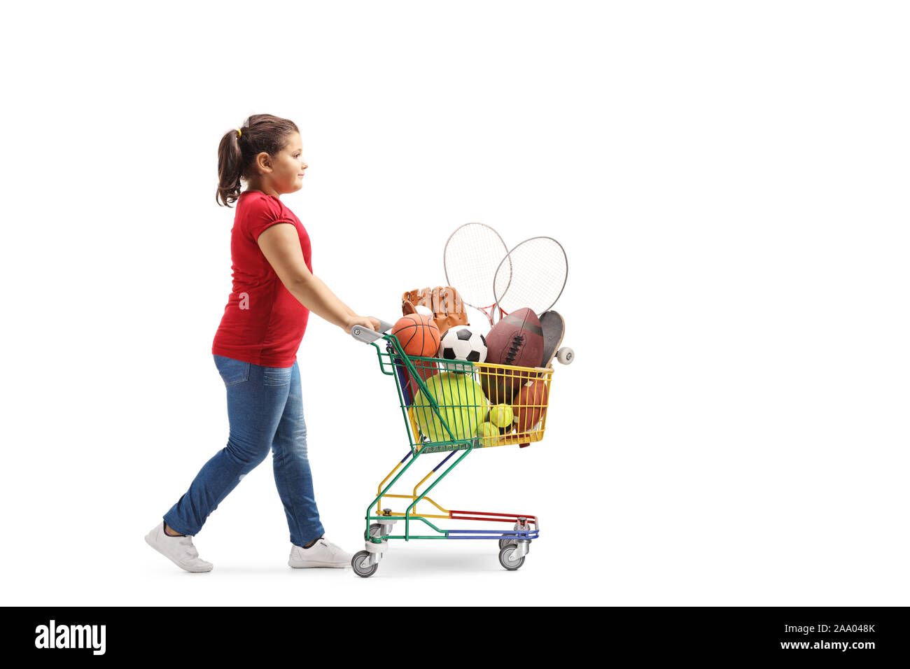 Full length profile shot of a girl walking and pushing a cart with sport items isolated on white background Stock Photo