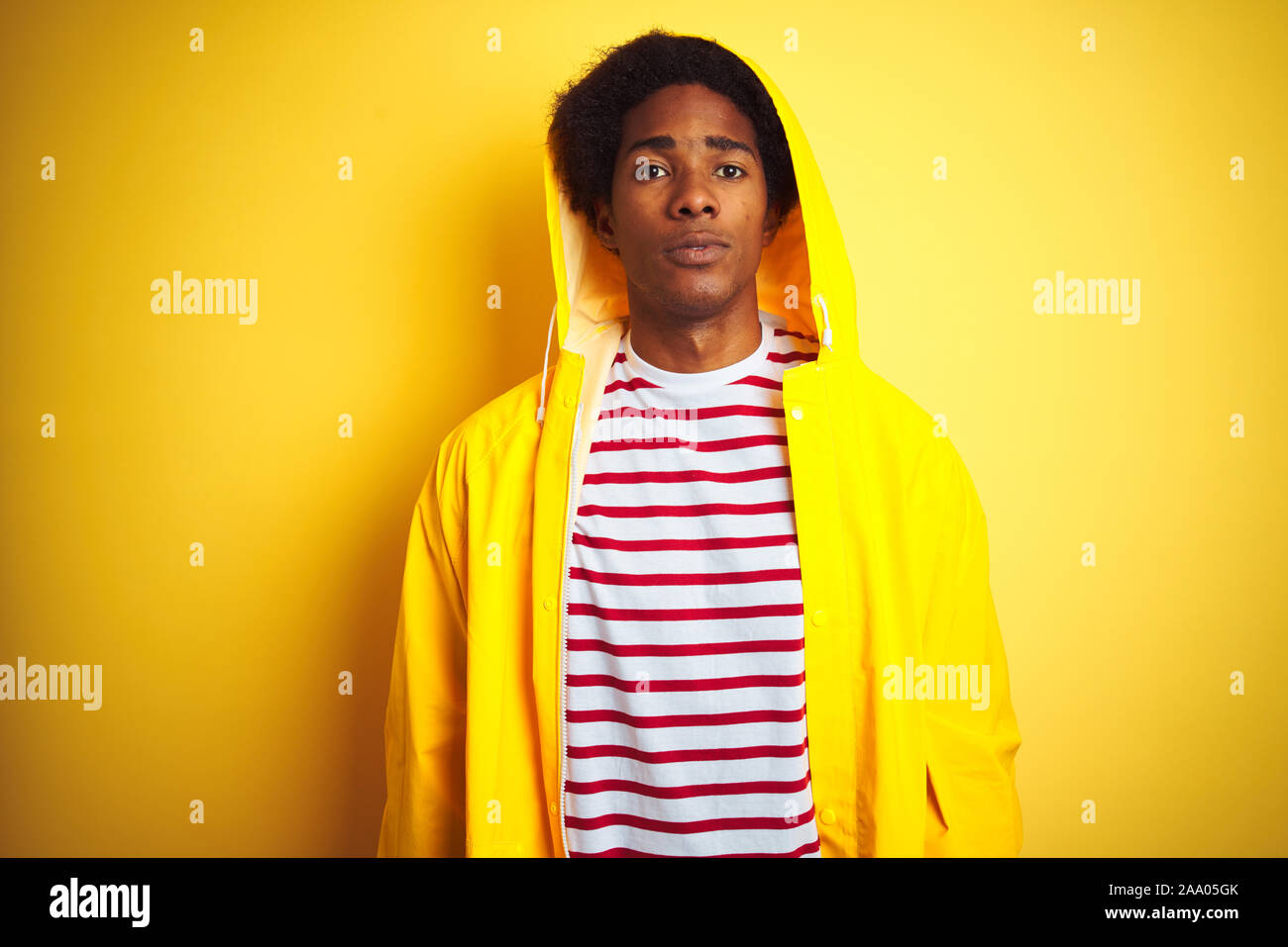 African Man With Afro Hair Wearing Rain Coat With Hood Standing