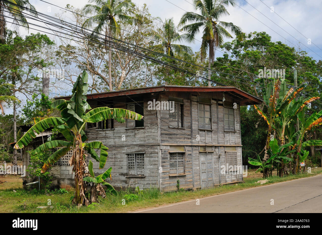 A typical twostoried wooden house is built close to the municipal road