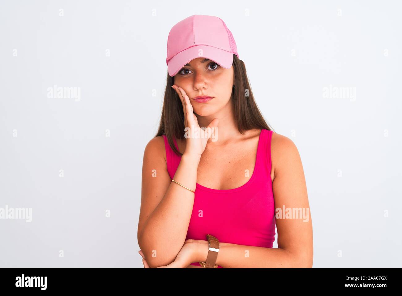 Young beautiful girl wearing pink casual t-shirt and cap over isolated white background thinking looking tired and bored with depression problems with Stock Photo