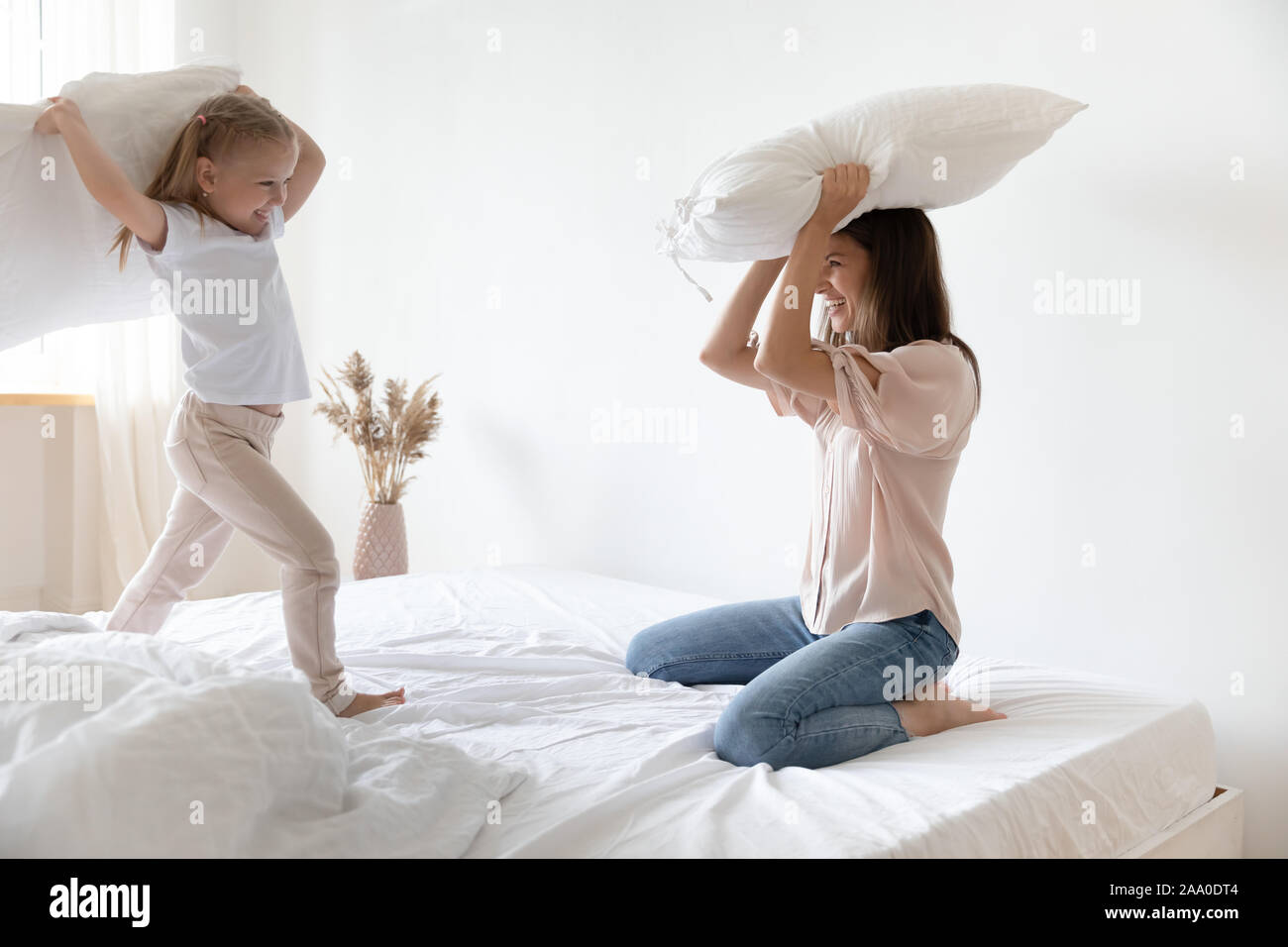 Overjoyed little preschool child girl playing fight with mother. Stock Photo