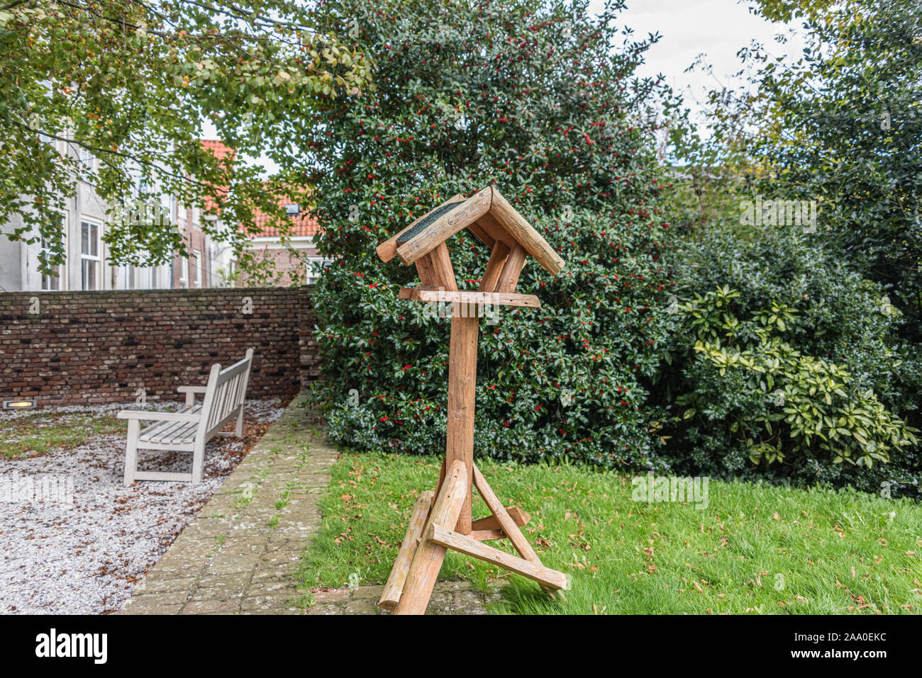 new birdhouse for feeding the birds mounted on a wooden pole Stock Photo