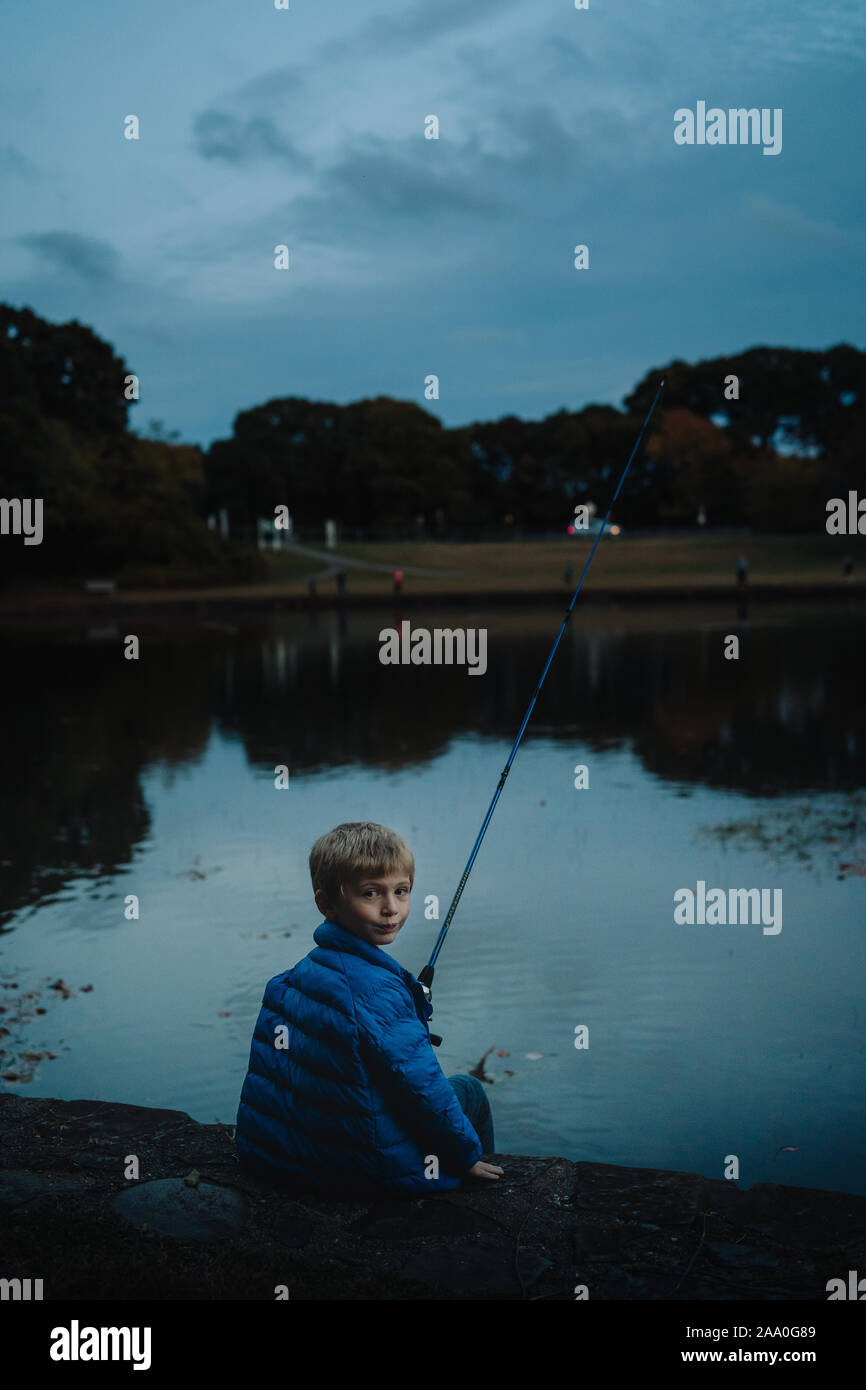 A little boy fishes in the evening. Stock Photo