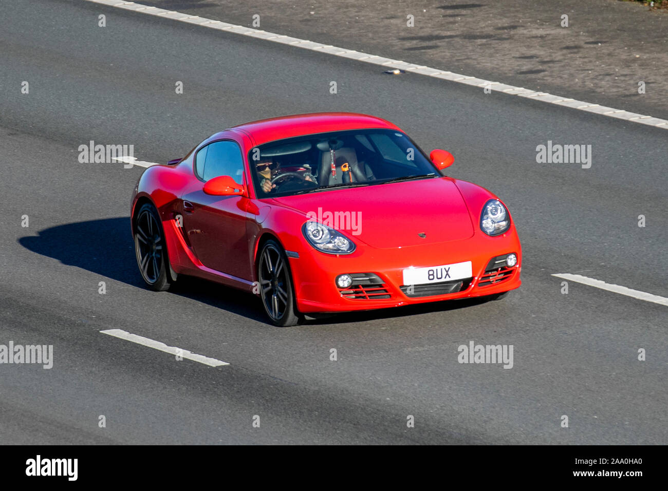 2011 red Porsche Cayman S-A with private number plate, personalised, cherished, dateless, DVLA registration marks, registrations,; UK Vehicular traffic, transport, modern vehicles, saloon cars, south-bound motoring on the 3 lane M6 motorway highway. Stock Photo