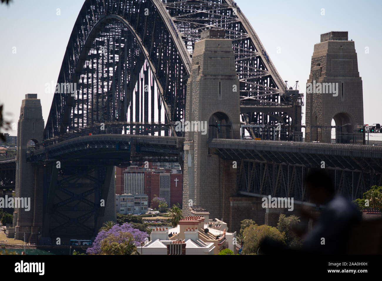 Sydney Harbour Bridge looking over terrace houses of the Rocks towards Milsons Point in the middle of the day Stock Photo