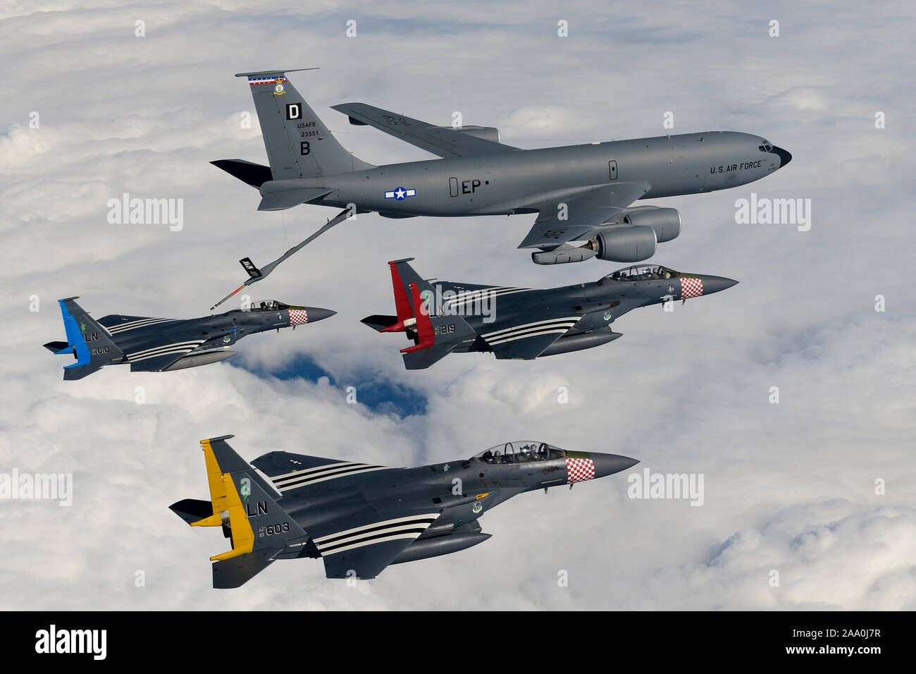 An F-15C Eagle and two F-15E Strike Eagles assigned to the 48th Fighter Wing, RAF Lakenheath, United Kingdom, painted with their respective squadron heritage color scheme, rendezvous with a KC-135 Stratotanker assigned to the 100th Air Refuelling Wing during a flypast over the MSPO Expo at Kielce, Poland, Sept. 3, 2019. The MSPO Expo is an international defense industry exhibition. Stock Photo