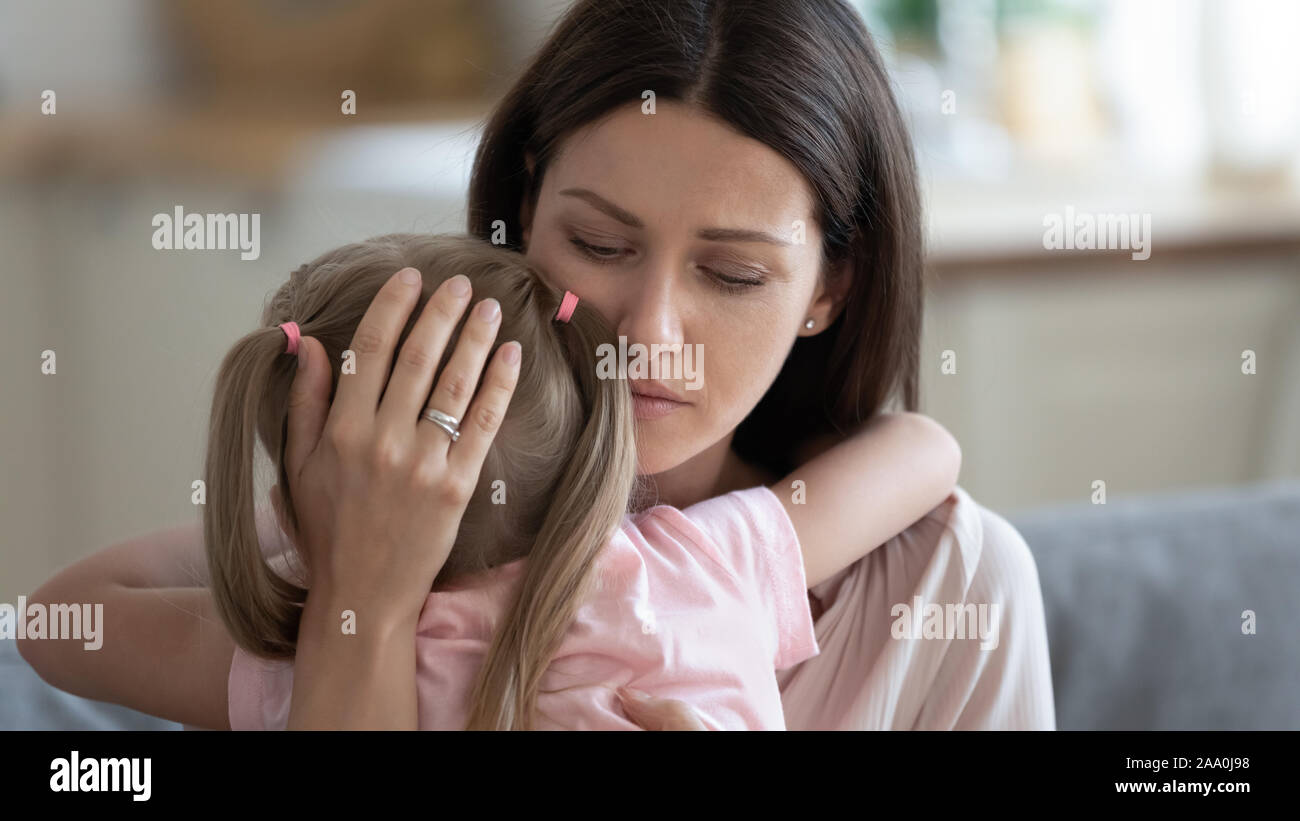 Compassionate young mother comforting little preschool daughter. Stock Photo