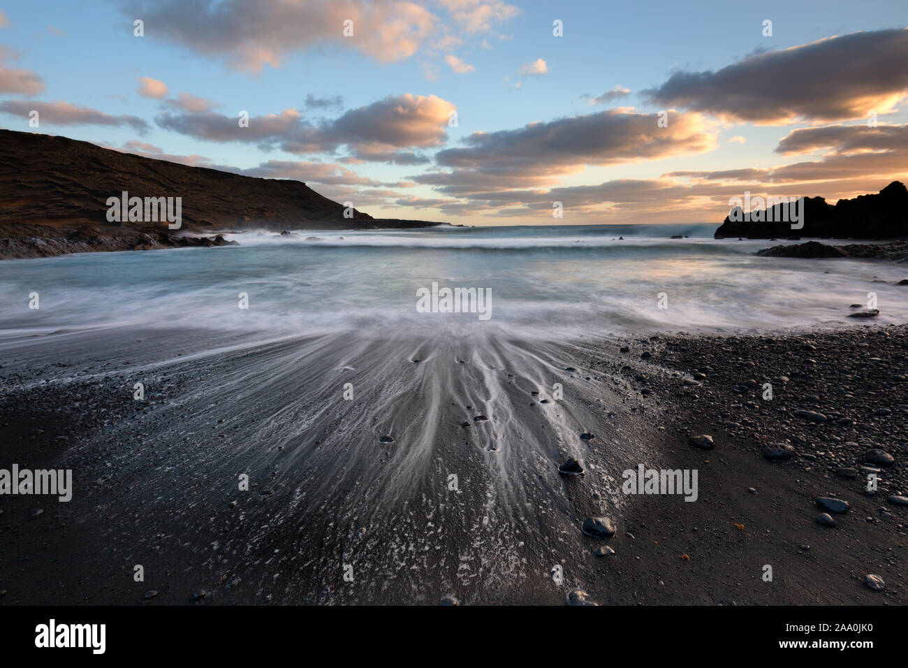 Receding wave on the black volcanic sand El Golfo beach, Lanzarote Stock Photo