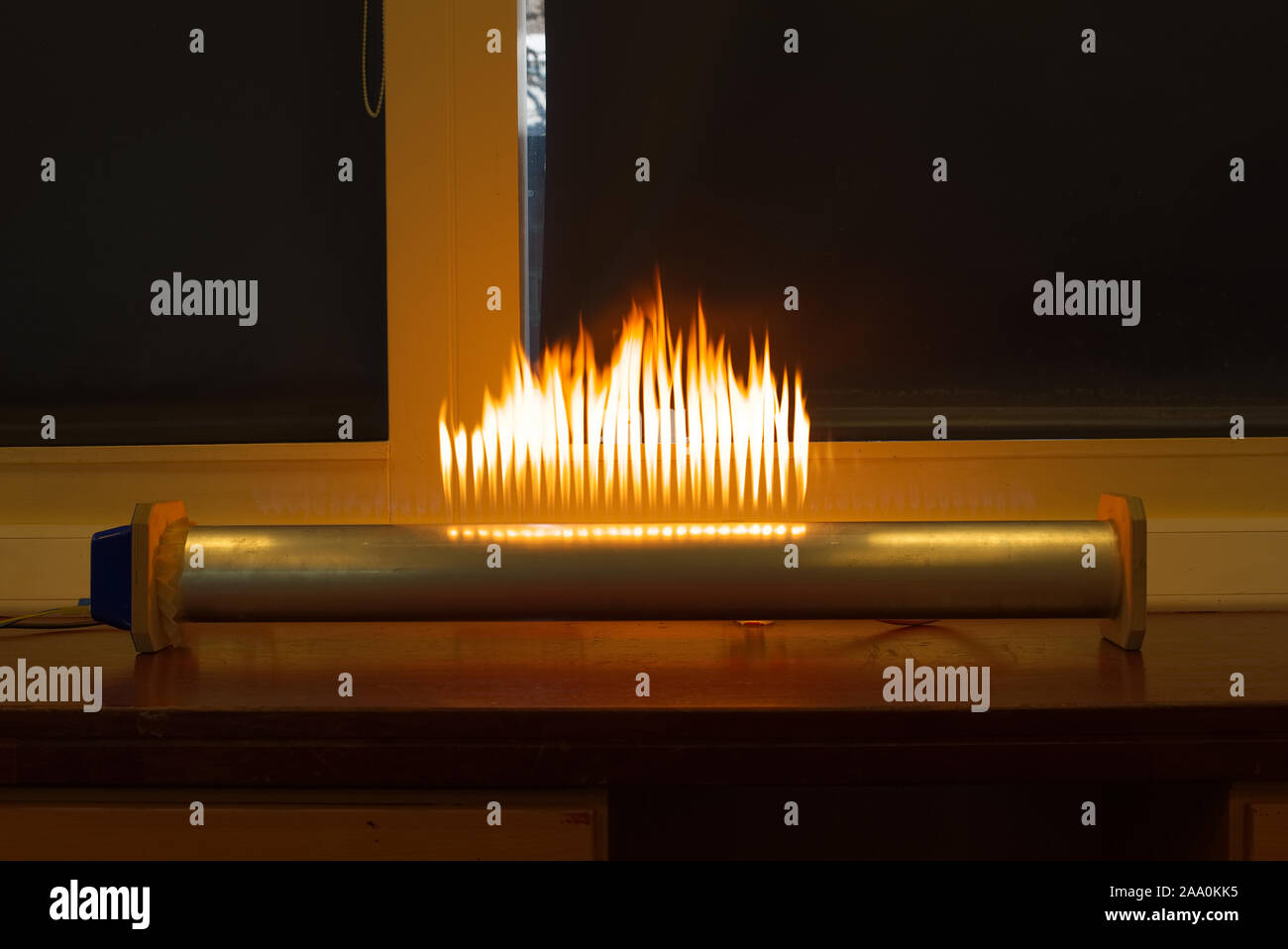 Rubens standing wave flame tube with flames showing resonance in a school science lab. Scientific education concept. Stock Photo
