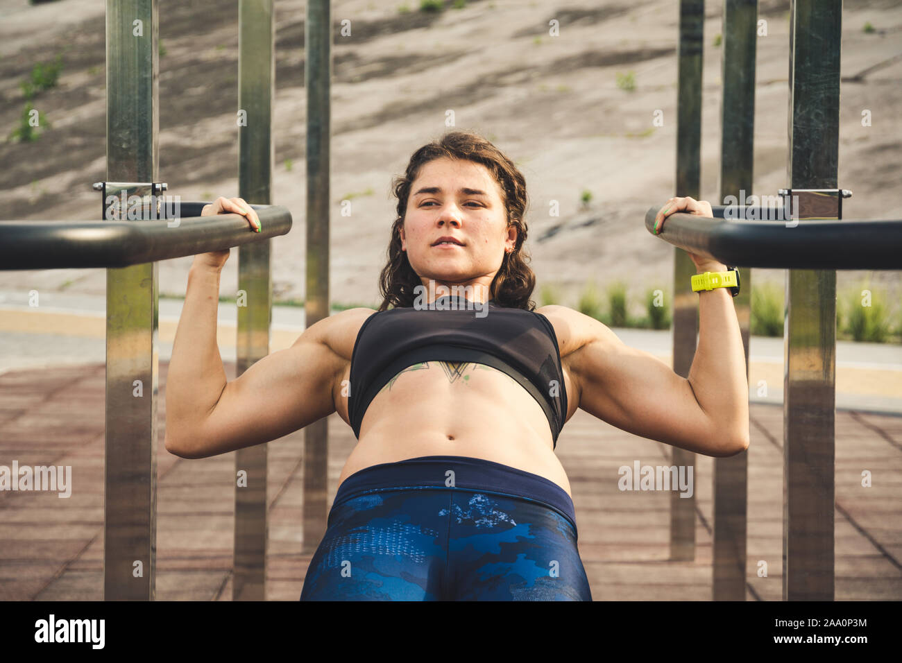 girl trains outdoors in street gym. Training of biceps and triceps. woman parallel bars workout exercise. female athlete exercising on parallel bars Stock Photo Alamy