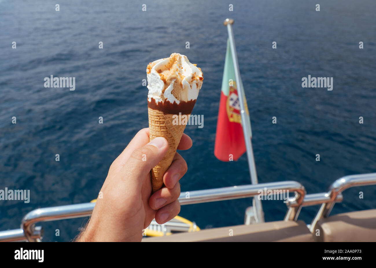 Ice cream in a waffle cup in man's hand on the yacht Stock Photo