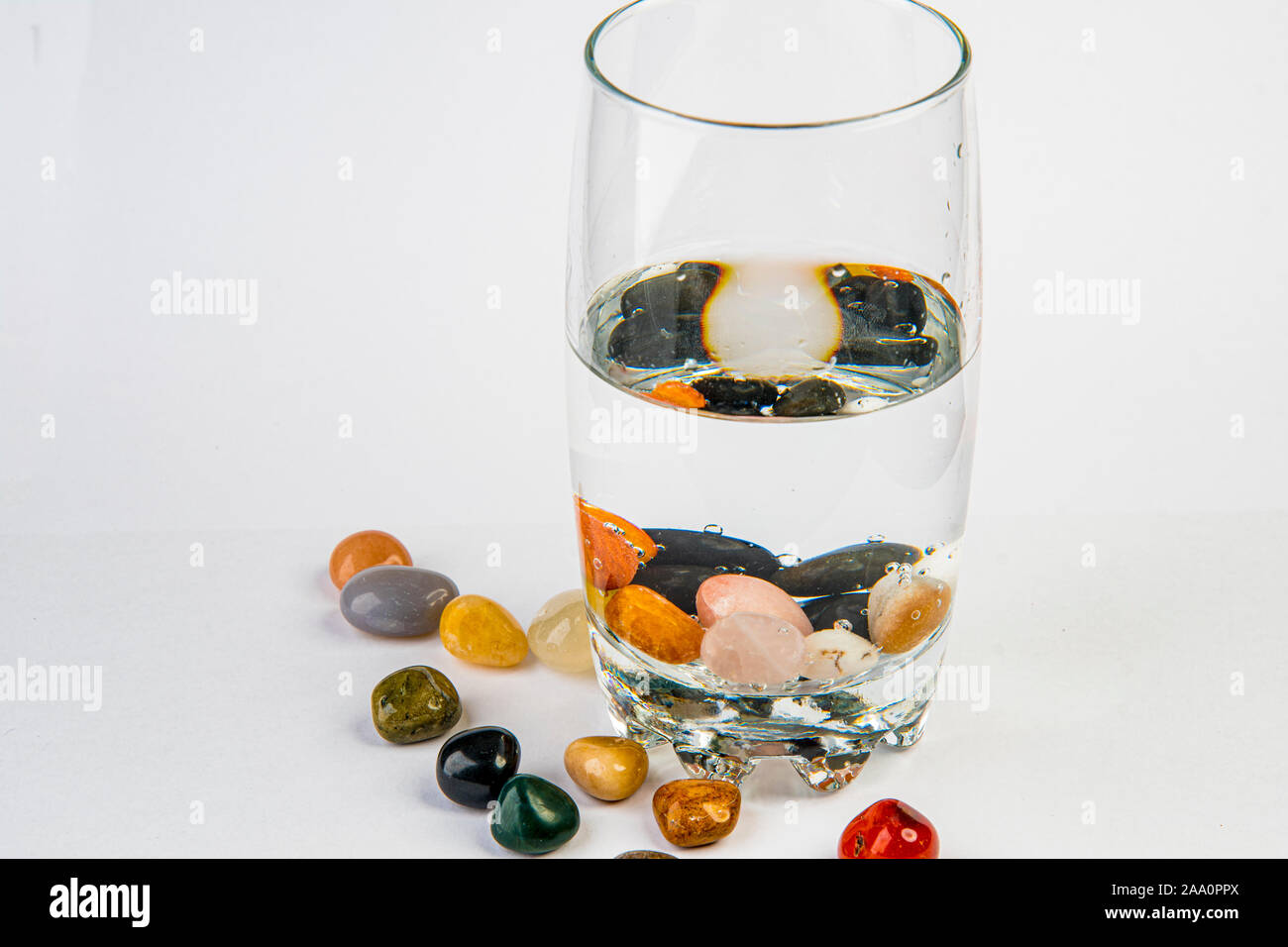 Glass with water and healing stones for Alternative Drink Stock Photo